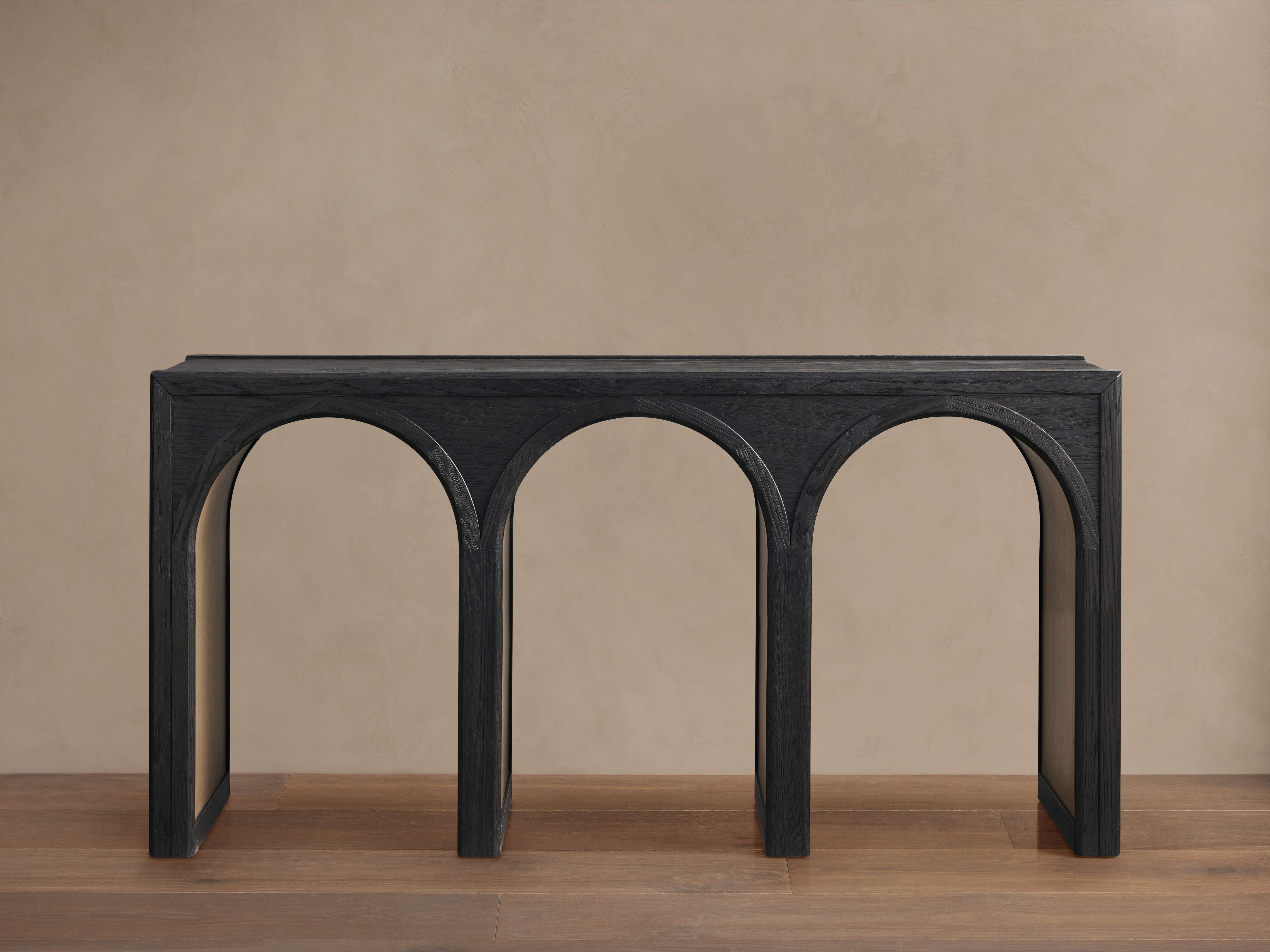 Dark wood arched console table with architectural triple-arch base