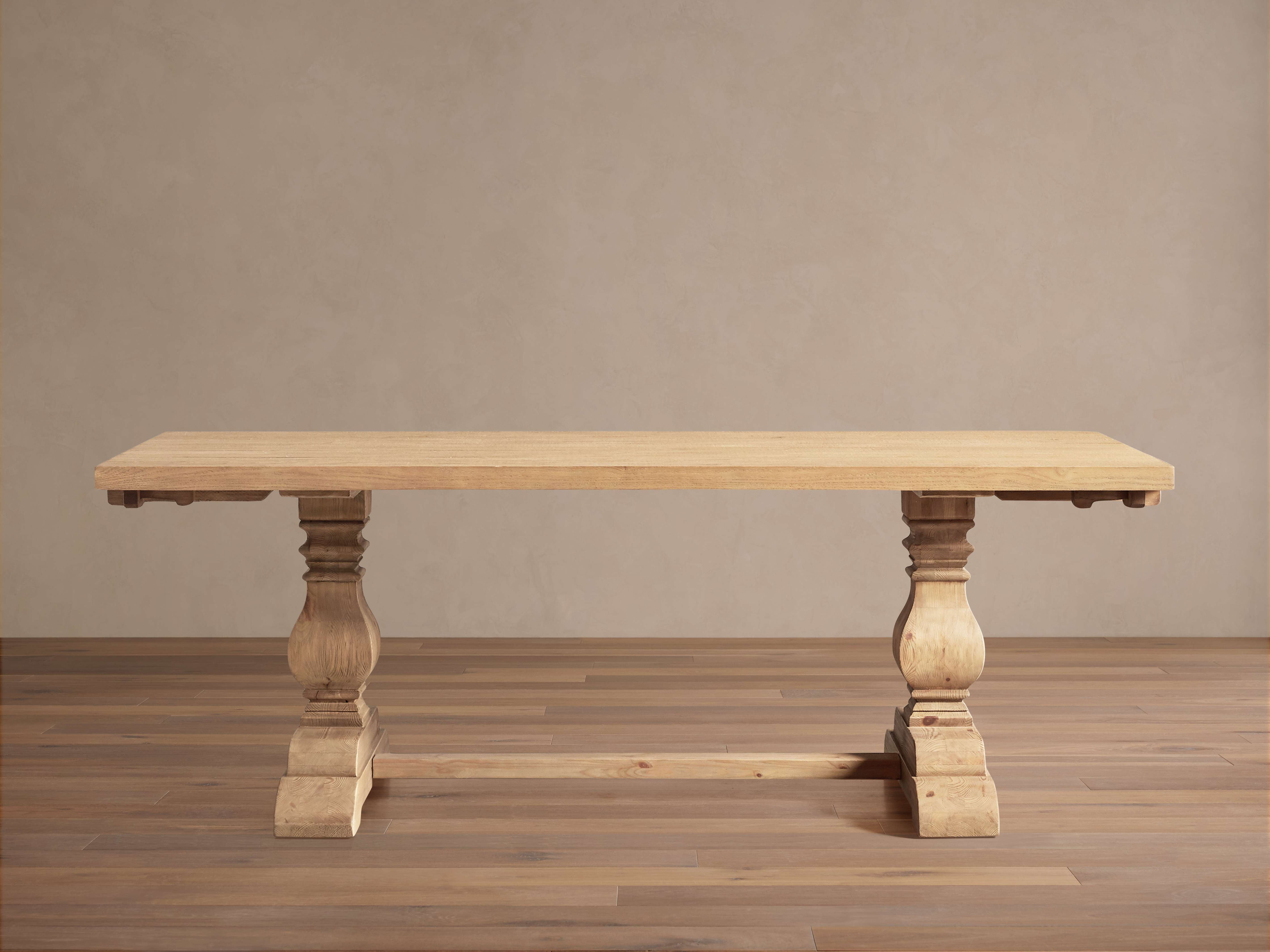 Solid wood trestle dining table with turned baluster legs and stretcher base